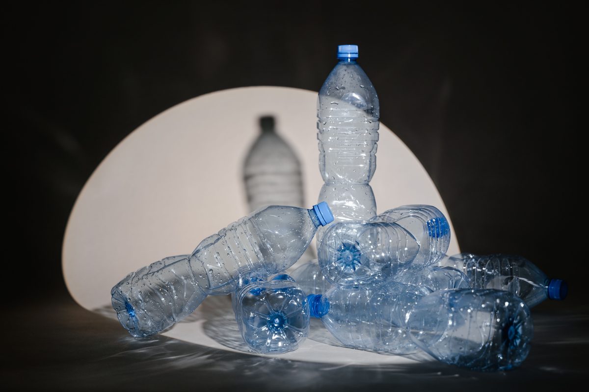 Botellas de bebida en PET, vidrio y aluminio sobre fondo claro